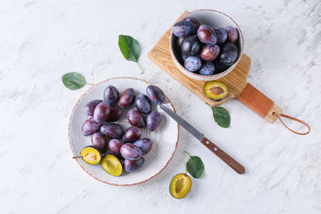 Plate with tasty plums on light backgroundの写真素材