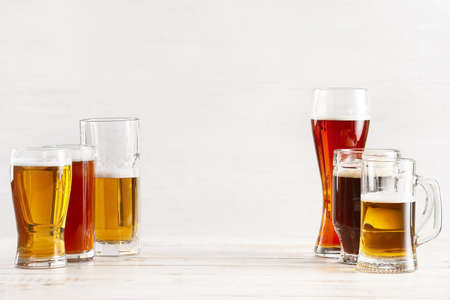 Glasses of different fresh beer on light backgroundの写真素材