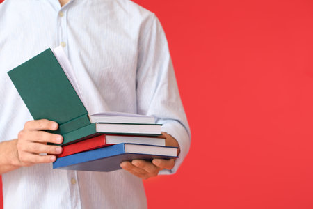 Young man with books on color background, closeupの写真素材