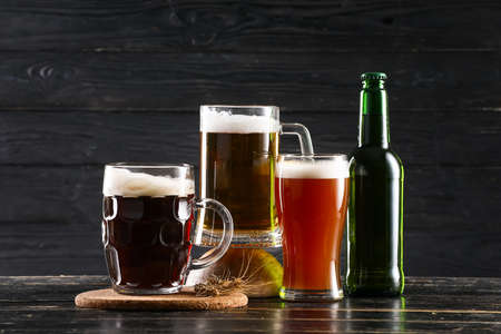 Glasses of different beer on dark wooden backgroundの写真素材