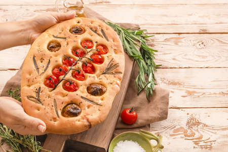 Woman with traditional Italian focaccia on wooden backgroundの写真素材