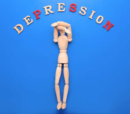Wooden mannequin with word DEPRESSION on color backgroundの写真素材