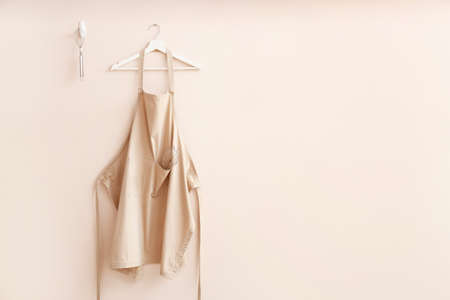 Clean apron and kitchen utensils on light backgroundの写真素材