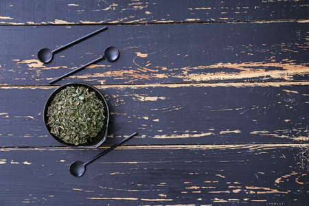 Bowl with dry tea leaves on wooden backgroundの写真素材