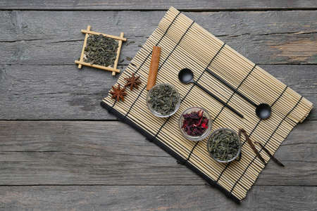 Composition with dry green tea on wooden background