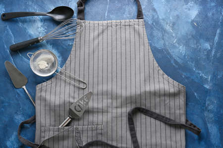 Apron and kitchen utensils on color backgroundの写真素材