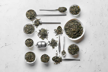 Composition with dry green tea leaves on light backgroundの写真素材