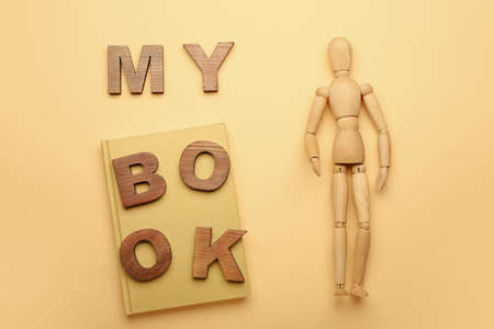 Wooden mannequin with words MY BOOK on color backgroundの写真素材