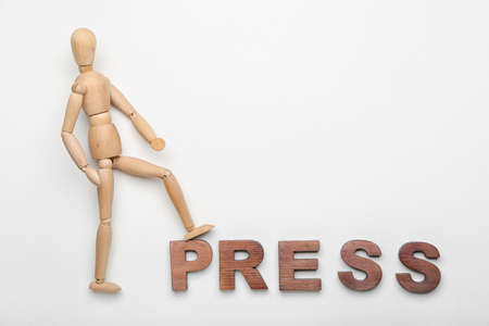 Wooden mannequin with word PRESS on white backgroundの写真素材