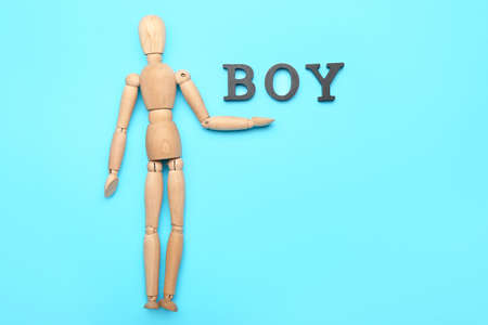 Wooden mannequin with word BOY on color backgroundの写真素材