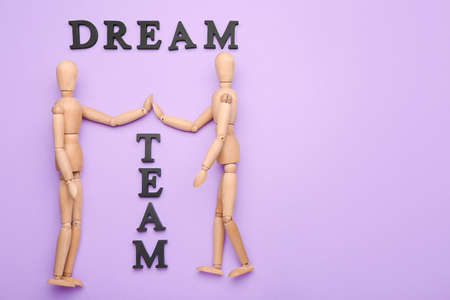 Wooden mannequins with words DREAM TEAM on color backgroundの写真素材