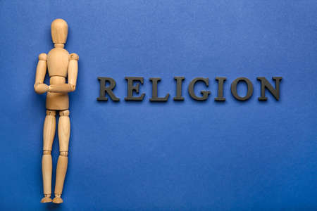 Wooden mannequin with word RELIGION on color backgroundの写真素材