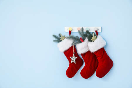 Beautiful Christmas socks hanging on color wall