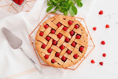 Stand with tasty raspberry pie on light tableの写真素材