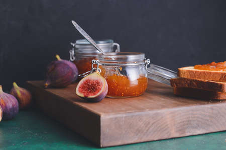 Glass jars with sweet fig jam on dark backgroundの写真素材