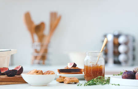 Glass jar with sweet fig jam on table