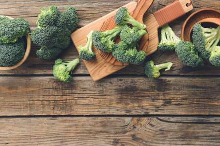 Board with fresh broccoli cabbage on wooden backgroundの写真素材