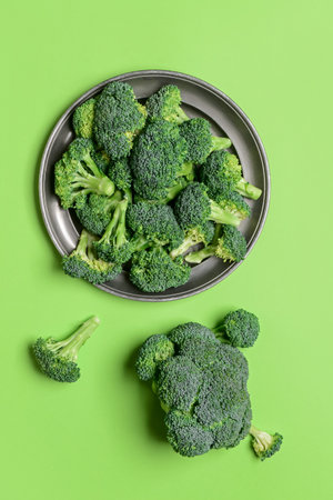 Plate with fresh broccoli cabbage on color backgroundの写真素材
