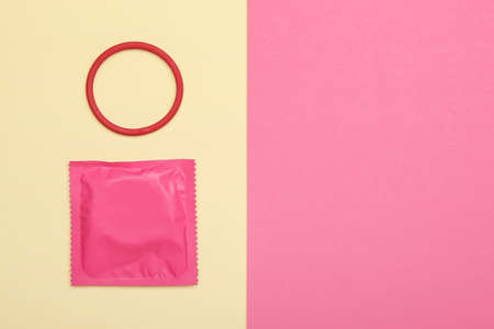 Wrapped condom and contraceptive ring on color backgroundの写真素材