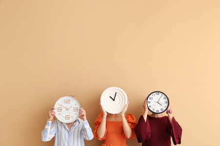Women with clocks on color backgroundの写真素材