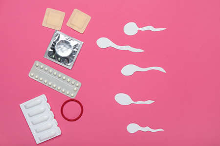 Different contraceptives and spermatozoa made of paper on color background. Safe sex conceptの写真素材