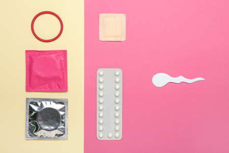 Different contraceptives and spermatozoa made of paper on color background. Safe sex conceptの写真素材