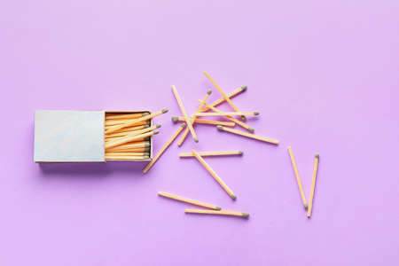 Box with matches on color background