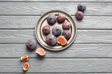 Plate with fresh figs on wooden backgroundの写真素材