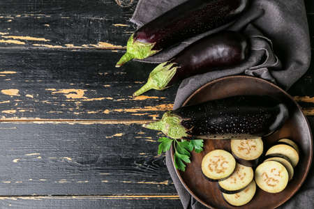 Composition with fresh eggplants on dark wooden backgroundの写真素材