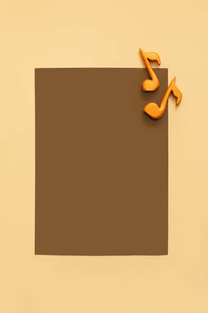 Music notes and blank sheet of paper on color background
