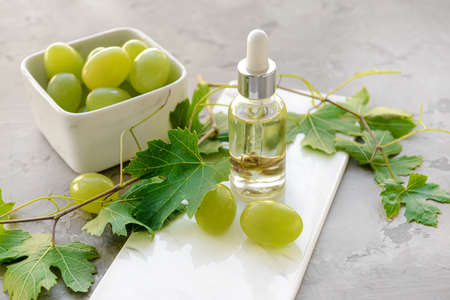 Bottle of grape seed oil on grunge background