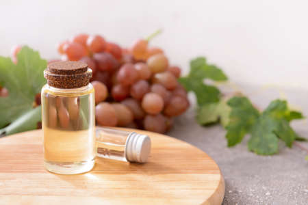 Board with bottles of grape seed oil on tableの写真素材