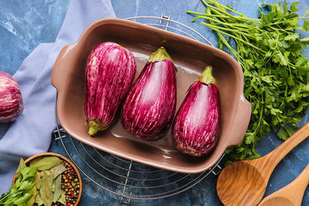 Baking dish with fresh eggplants on color backgroundの写真素材