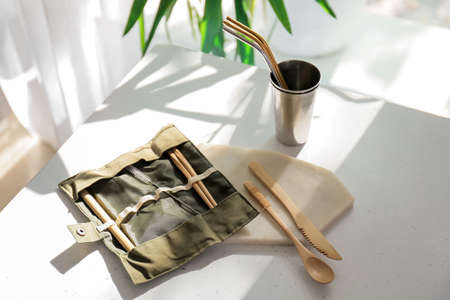 Eco cutlery and cup on table in kitchen