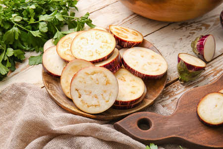 Plate with sliced eggplant on wooden backgroundの写真素材
