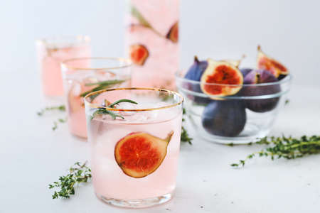 Glasses of tasty fig lemonade on light backgroundの写真素材