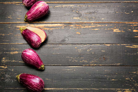 Fresh eggplants on dark wooden background