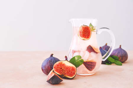 Jug of tasty fig lemonade on color backgroundの写真素材