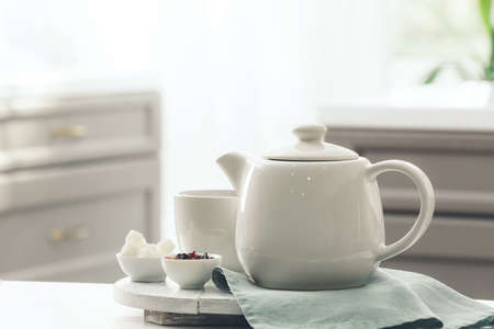 Tray with teapot and cup on table