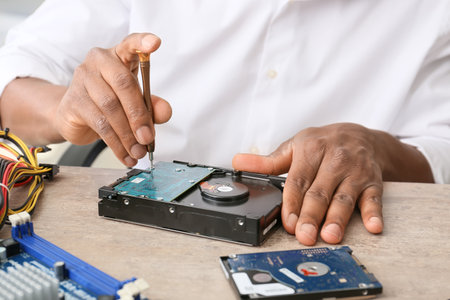 African-American technician repairing computer in service center, closeupの写真素材