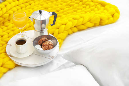 Tray with tasty breakfast on bed