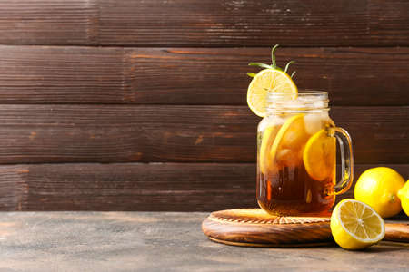 Mason jar of cold black tea with lemon on wooden backgroundの写真素材