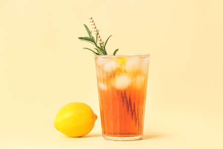 Glass of cold black tea with lemon on color backgroundの写真素材