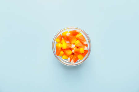 Tasty candies for Halloween in bowl on color backgroundの写真素材