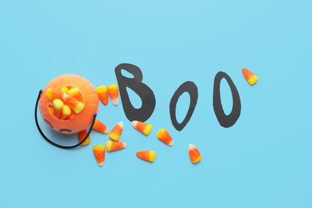 Composition with tasty candies for Halloween on color background