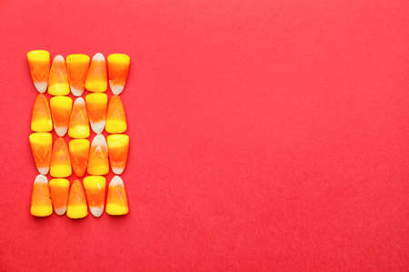 Tasty candies for Halloween on color background