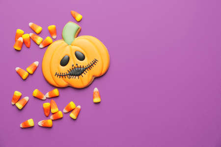 Tasty candies and cookie for Halloween on color backgroundの写真素材