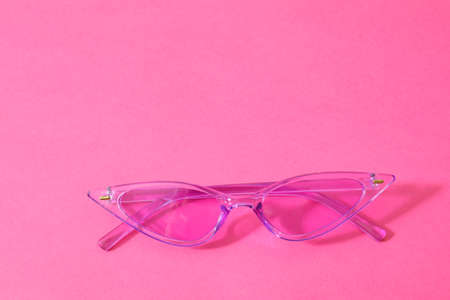 Stylish sunglasses on color background