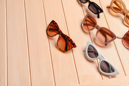 Stylish sunglasses on color background