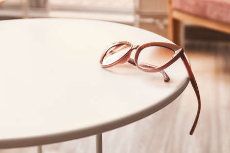 Stylish female sunglasses on table